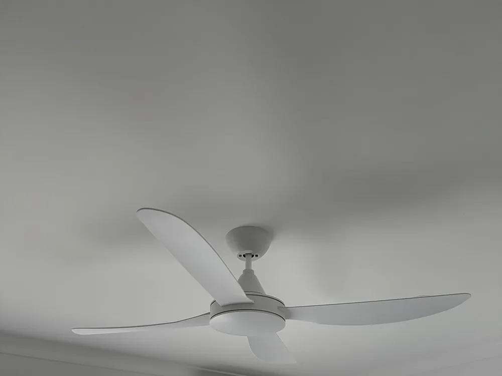 New white three-blade ceiling fan installed in a bedroom