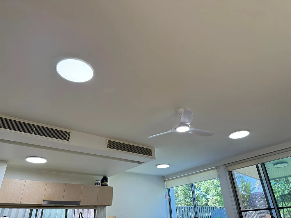Round LED panel lights and a ceiling fan in a freshly upgraded living area ceiling