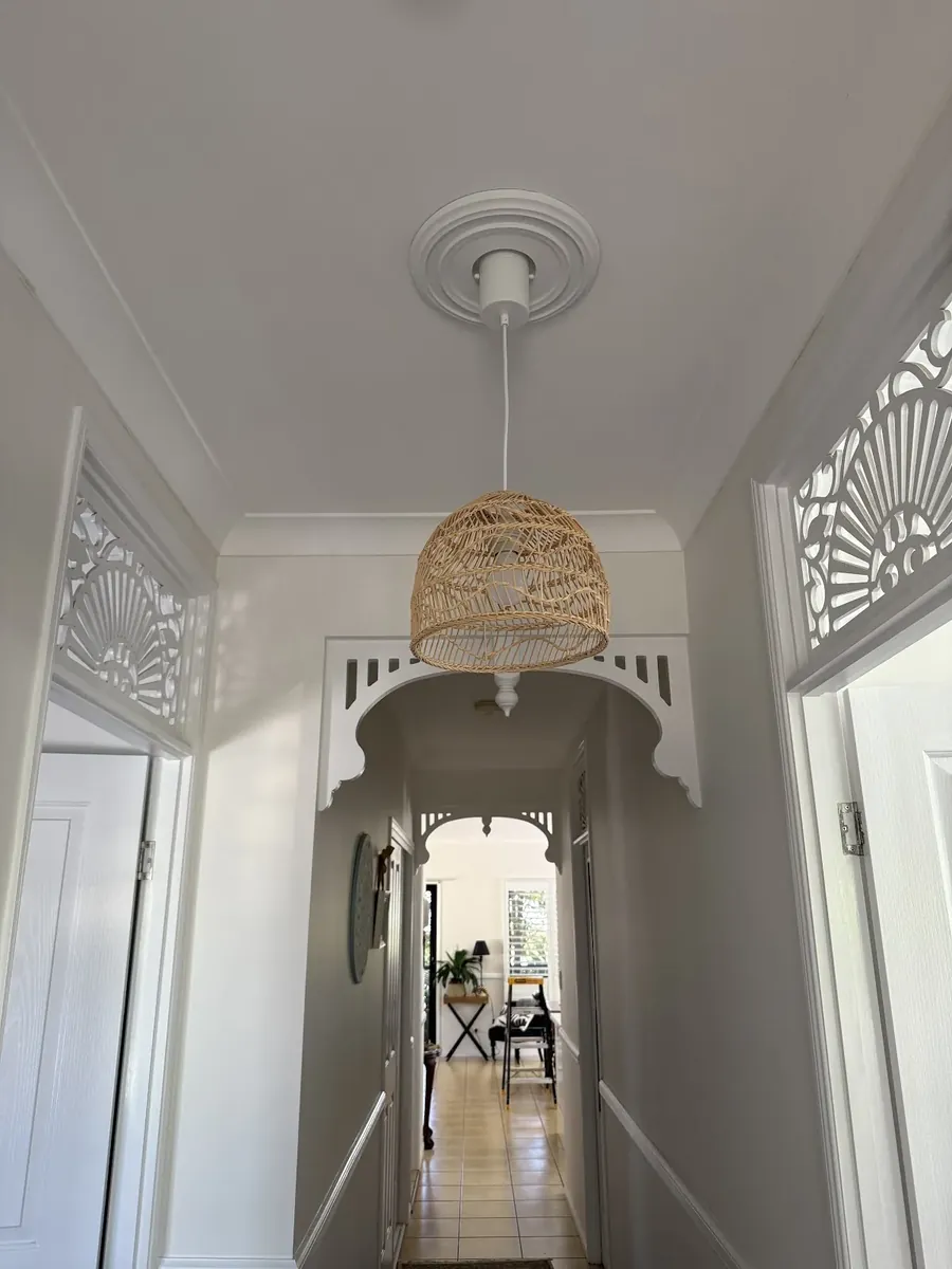 Woven pendant light in a hallway with decorative fretwork