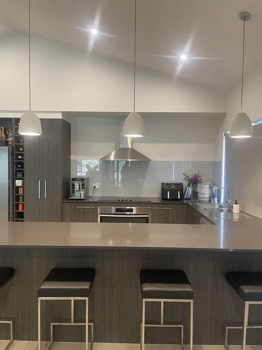 Kitchen with white pendants over the bench and LED downlights