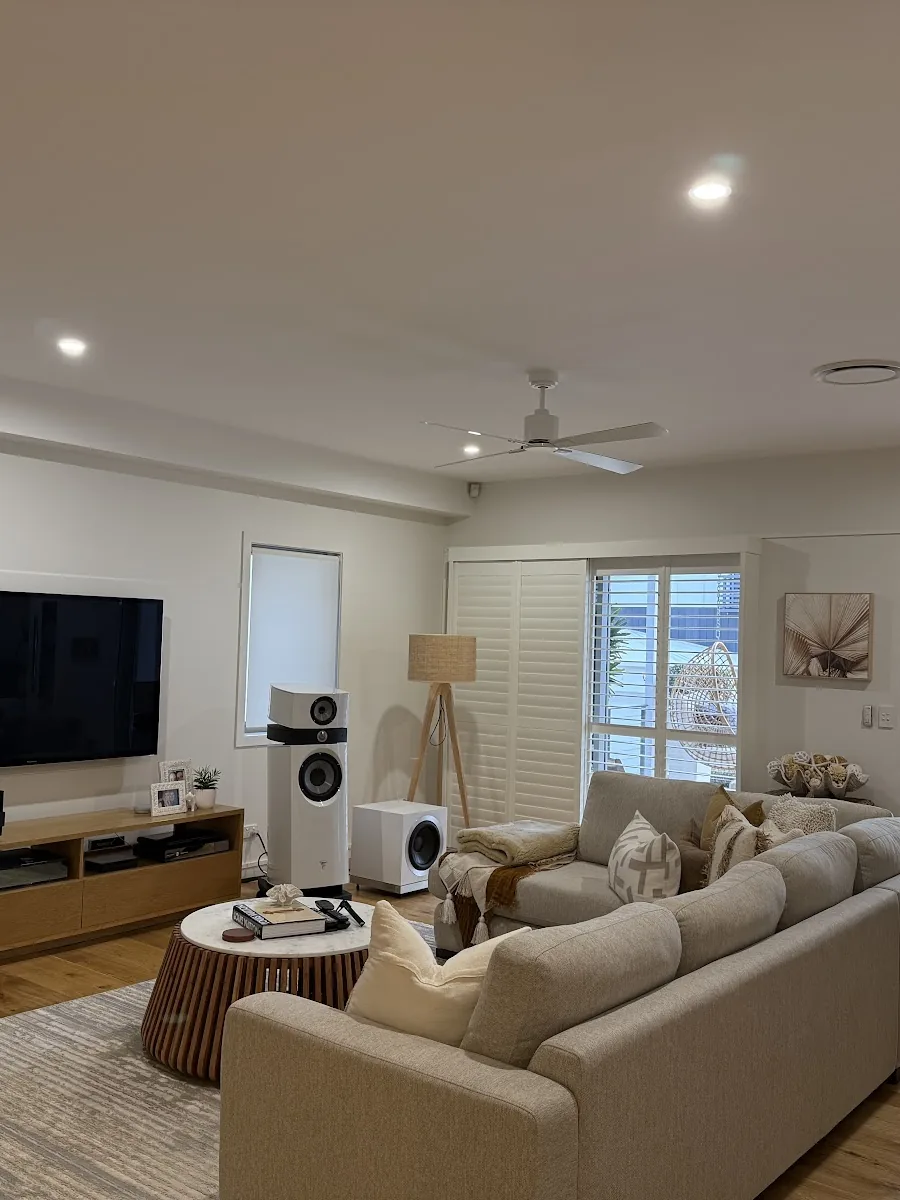 Living room with LED downlights and a ceiling fan above the lounge
