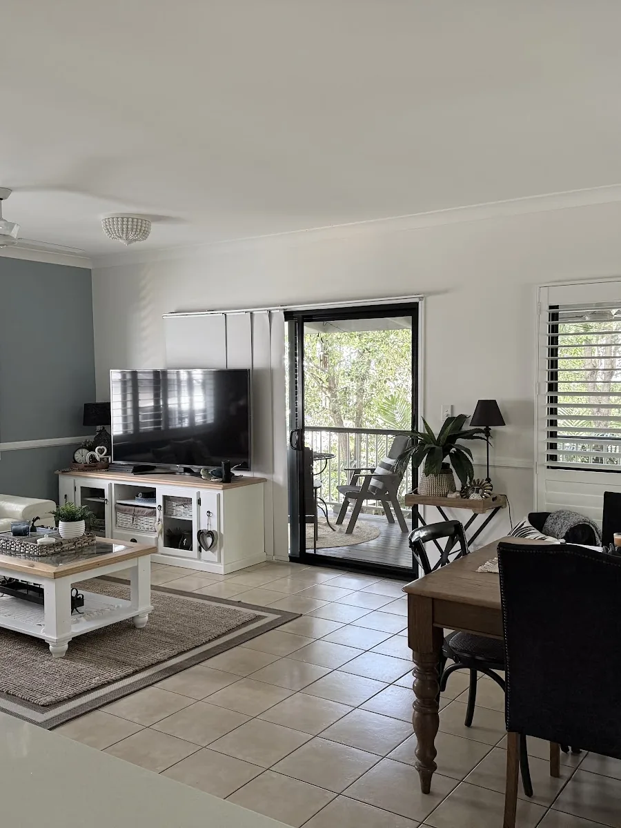 Open plan living and dining room with a woven pendant light and ceiling fan